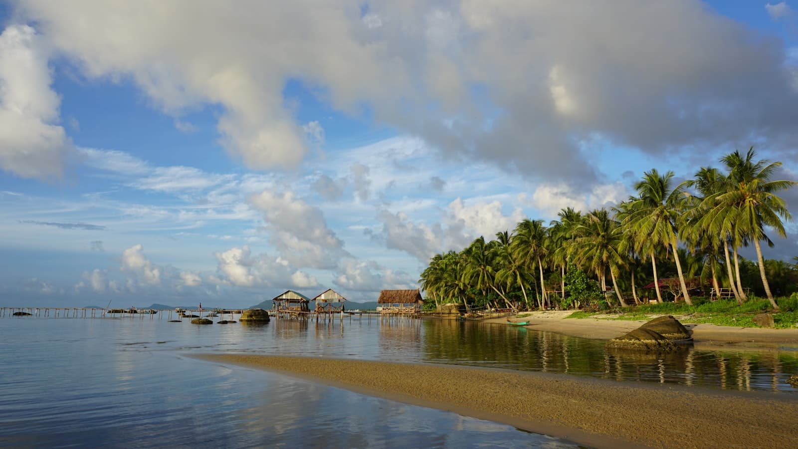 Phú Quốc — a beach with palm trees and houses on the shore