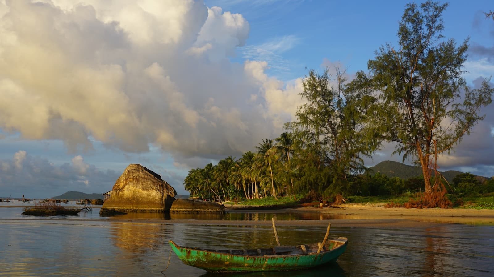 Phú Quốc — a green boat sitting on top of a body of water
