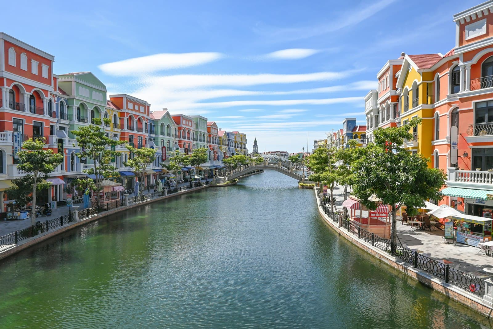 Phú Quốc — Colorful buildings line a canal with a bridge.