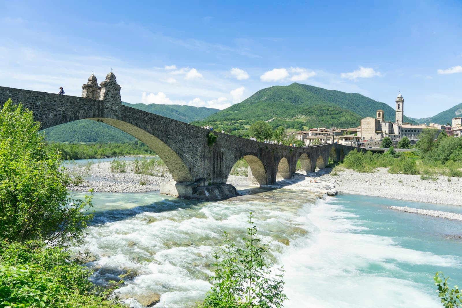Piacenza — a bridge over a river with a castle in the background
