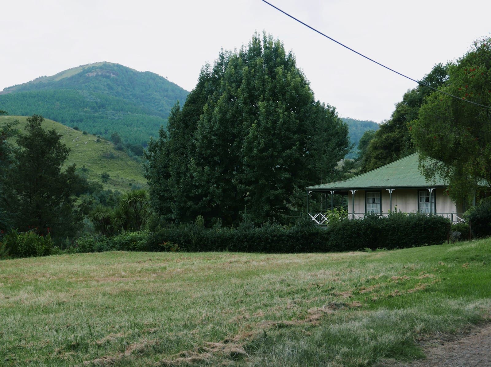 Pilgrim's Rest — a house in the middle of a field with mountains in the background