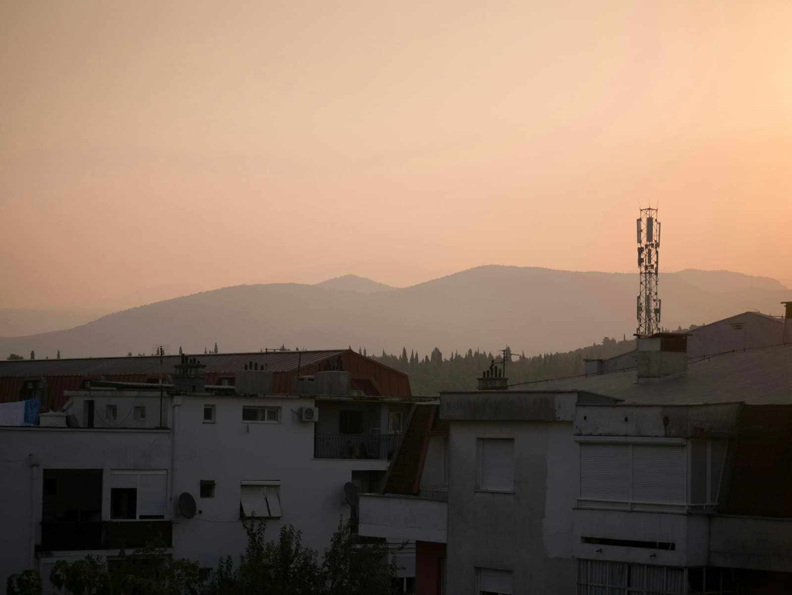 Podgorica — The sun is setting over a city with mountains in the background