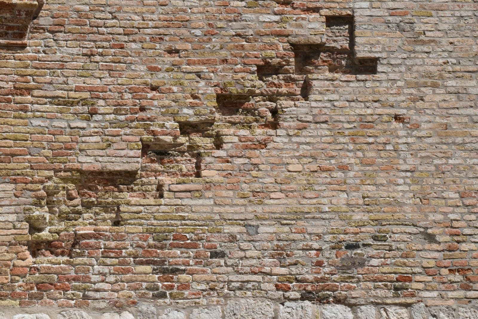 Pordenone — A weathered brick wall with crumbling sections.