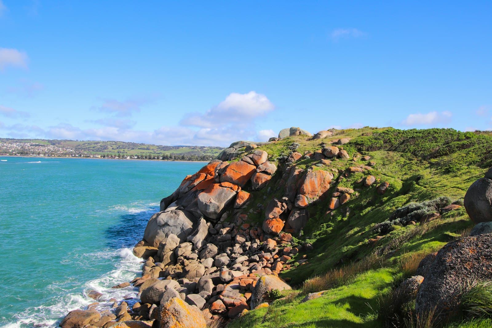 Port Fairy — A large body of water sitting next to a lush green hillside