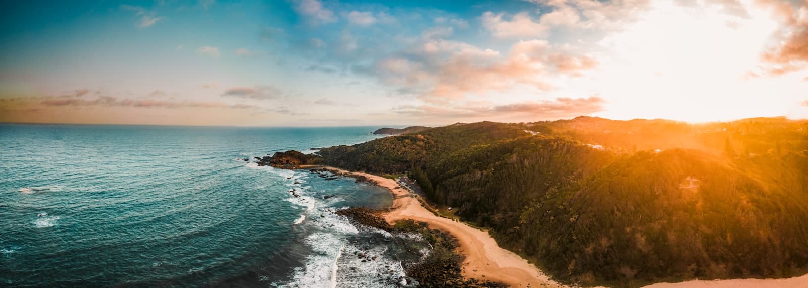 Port Macquarie — an aerial view of a beach and ocean at sunset