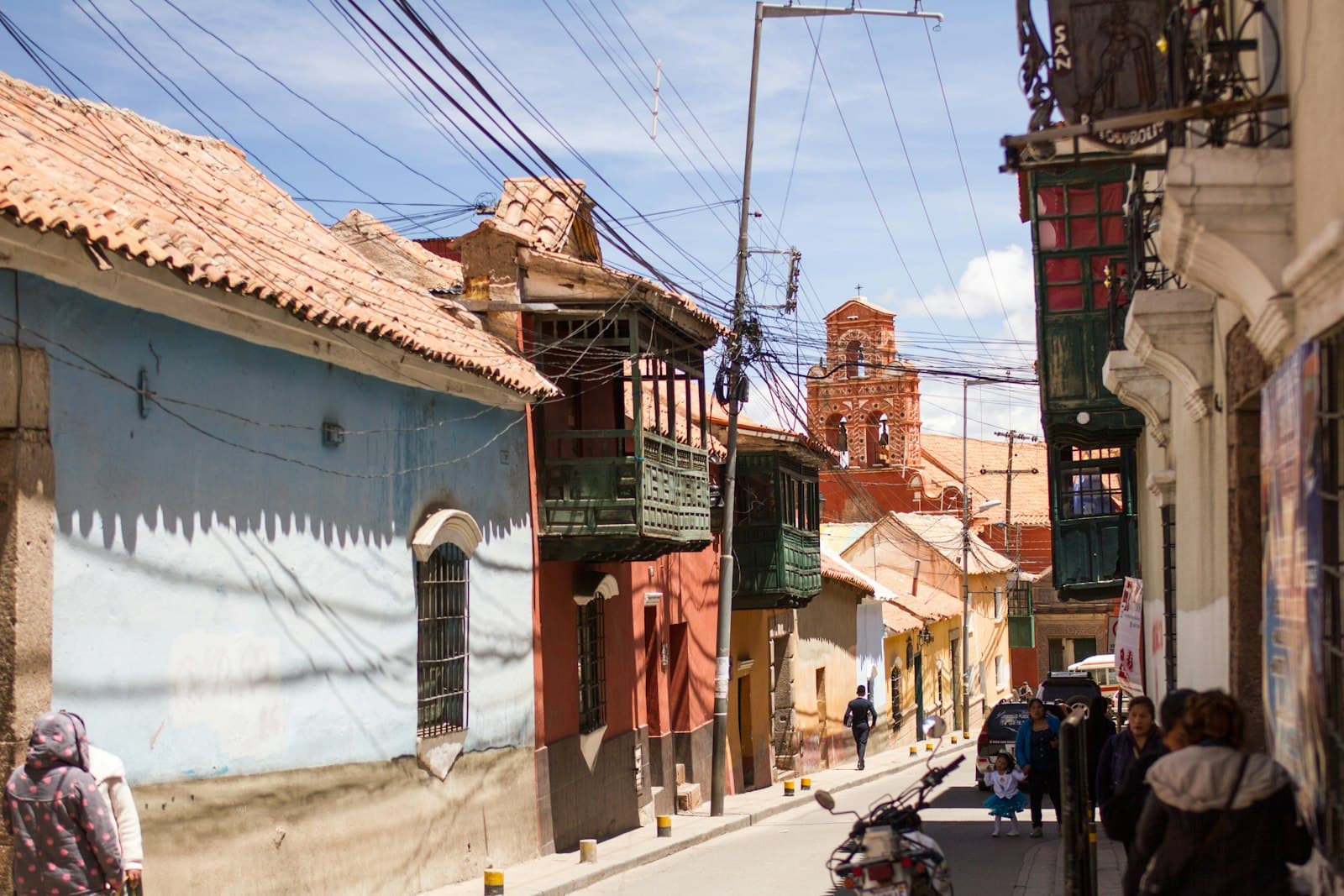 Potosí — a group of people walking down a street next to tall buildings