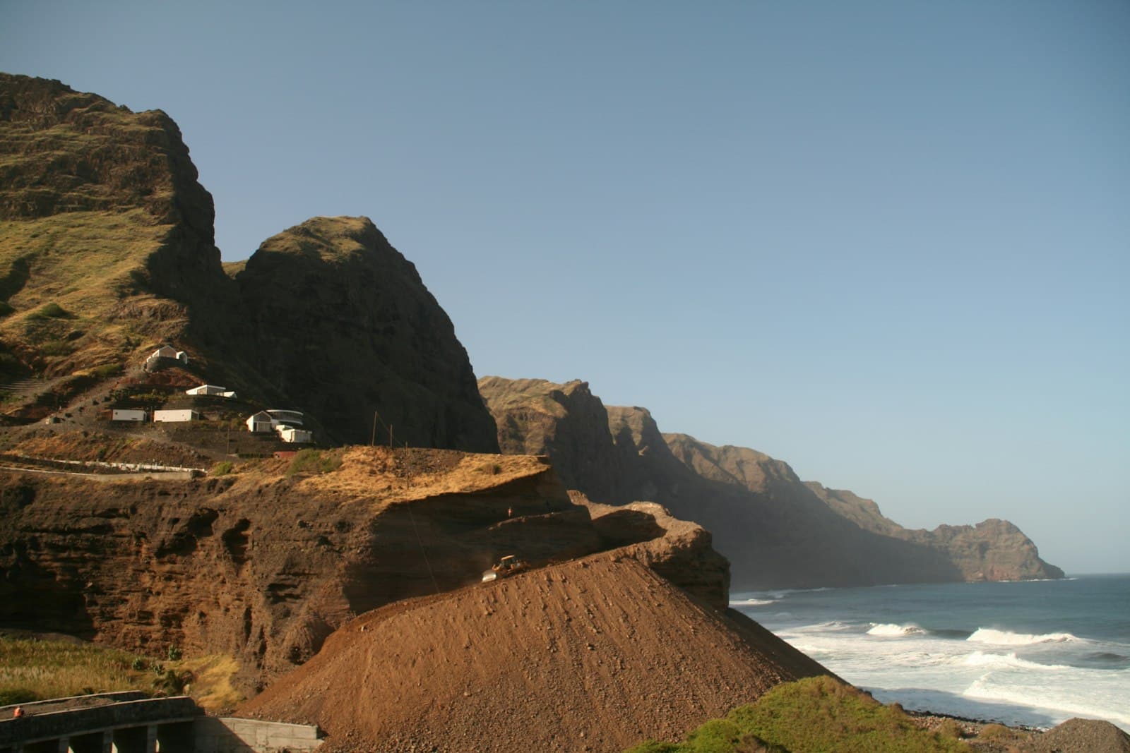 Praia — a cliff with a house on top of it next to the ocean