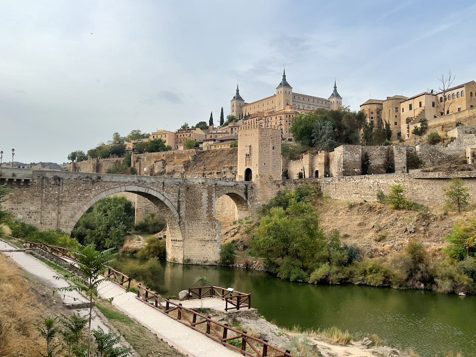 Priego de Córdoba — a bridge over a river with a castle in the background