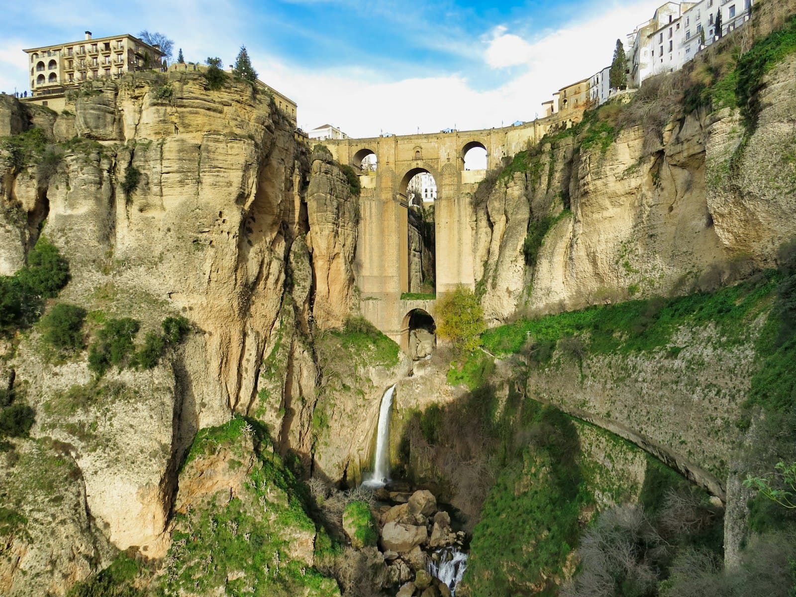 Priego de Córdoba — waterfalls blow concrete bridge and buildings at daytime