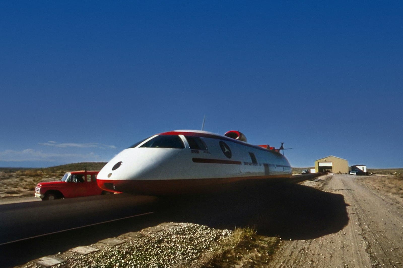 Pueblo — a white and red train traveling down a dirt road