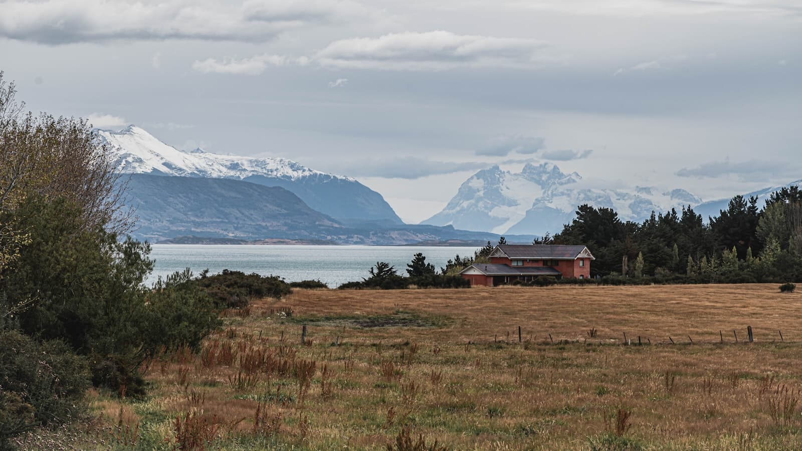 Puerto Natales — a house in a field with mountains in the background