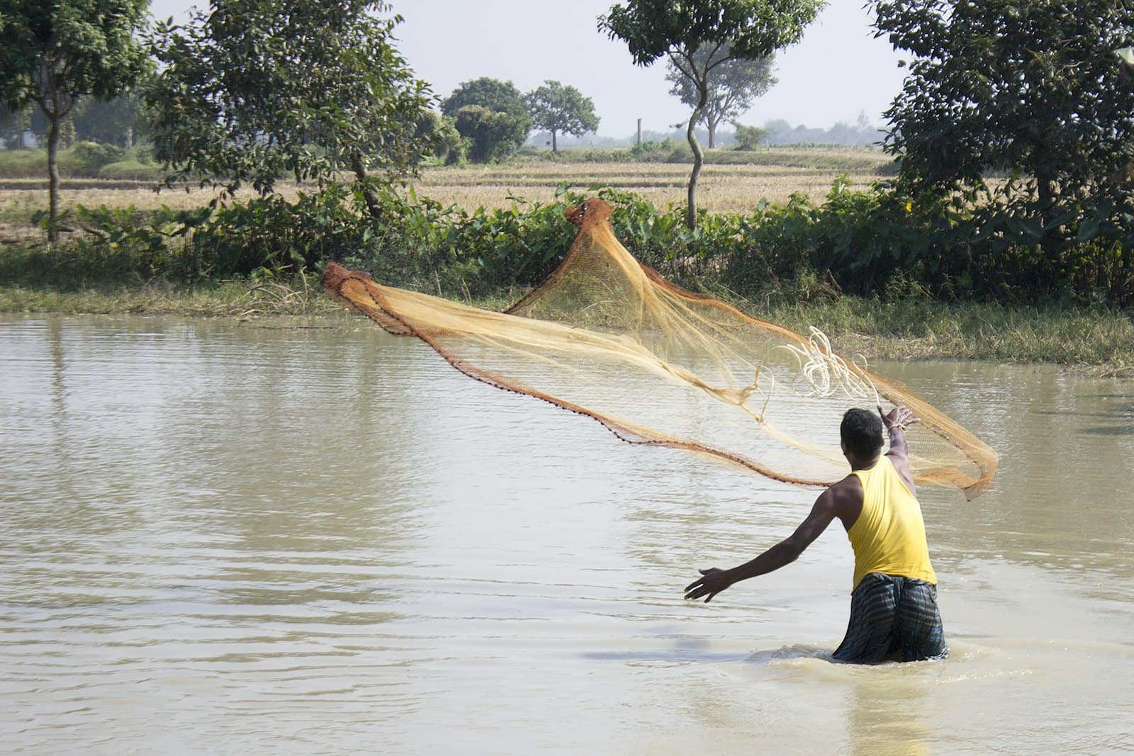 Rajshahi — woman in black tank top and black shorts standing on water during daytime