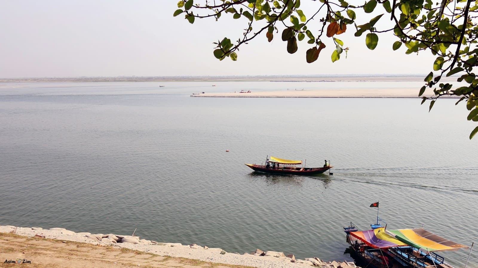 Rajshahi — A boat sails peacefully on a wide river