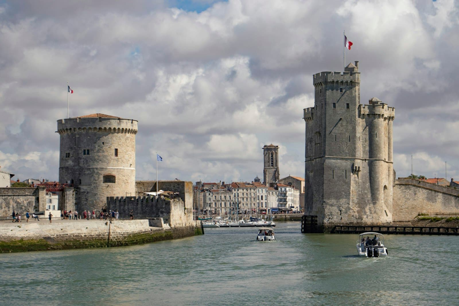 Rochefort-en-Terre — brown concrete building near body of water under cloudy sky during daytime