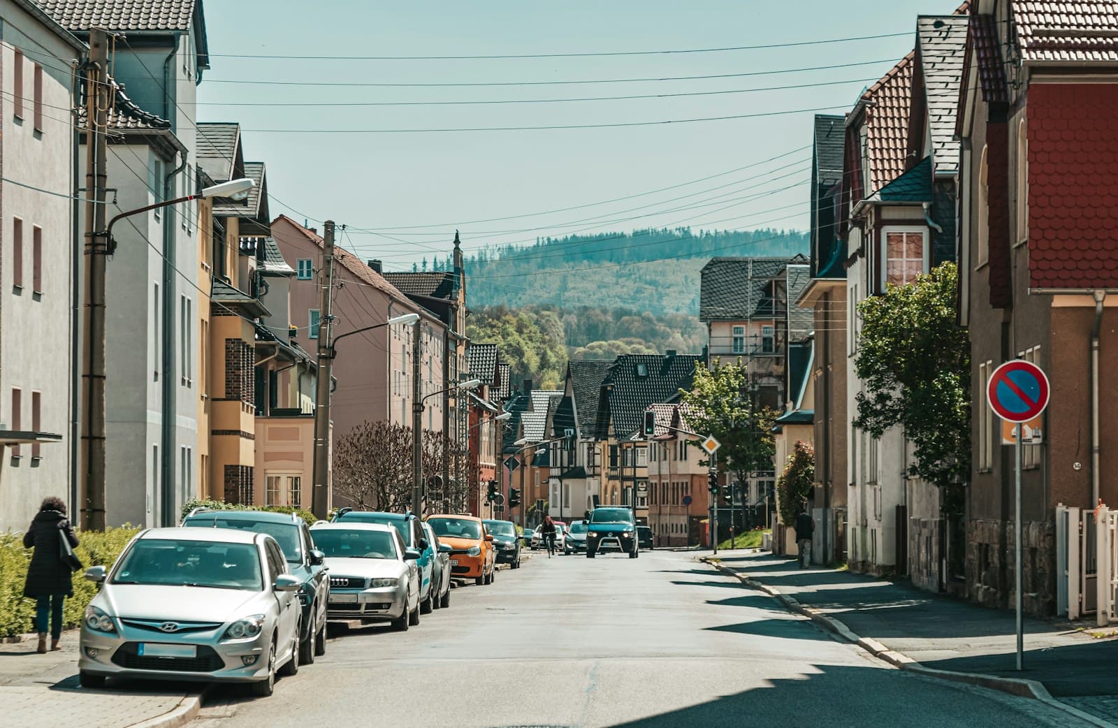 Saalfeld — a woman walking down a street next to parked cars