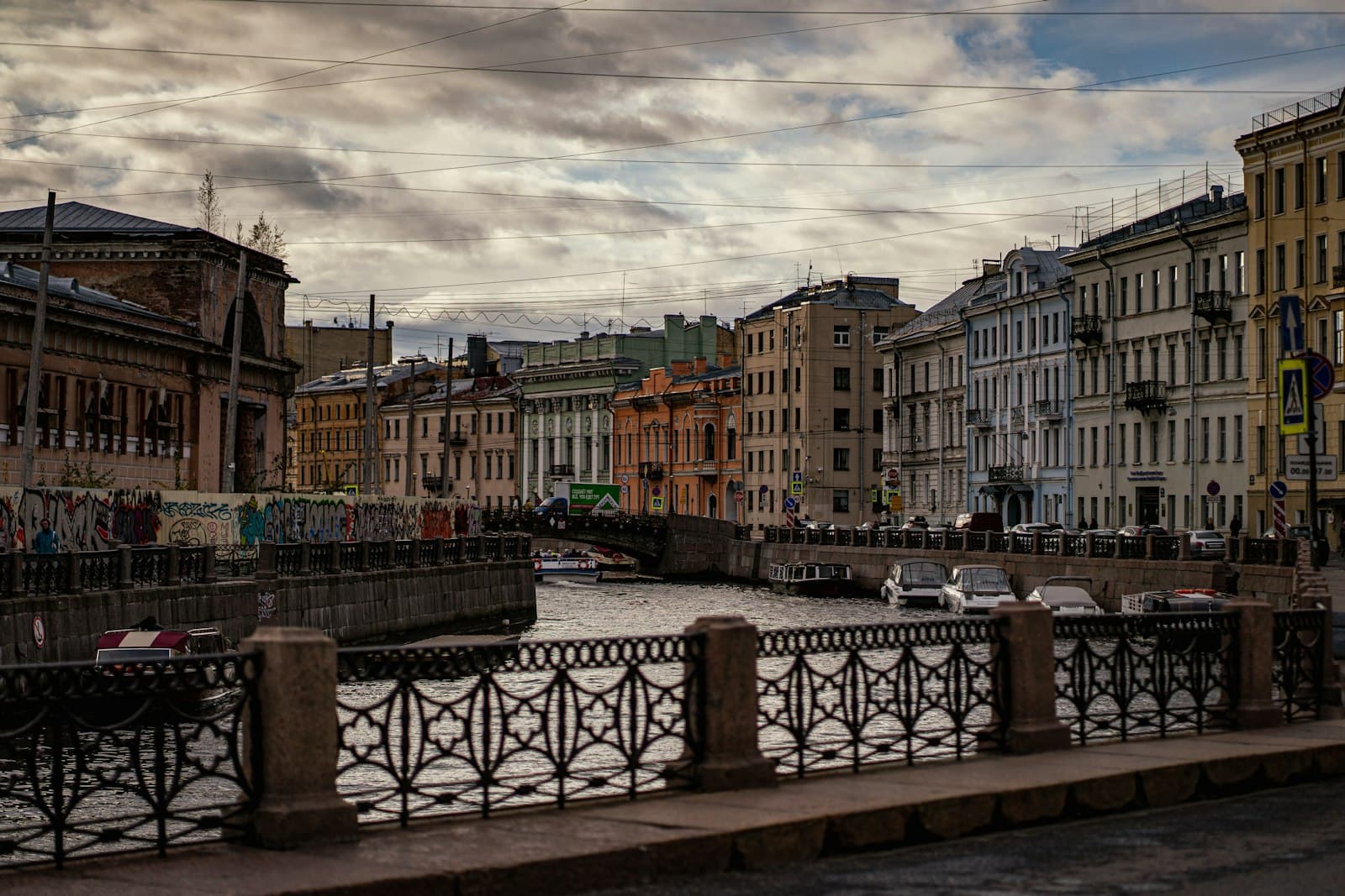 Saint Petersburg — black metal bench near brown concrete building under white clouds during daytime