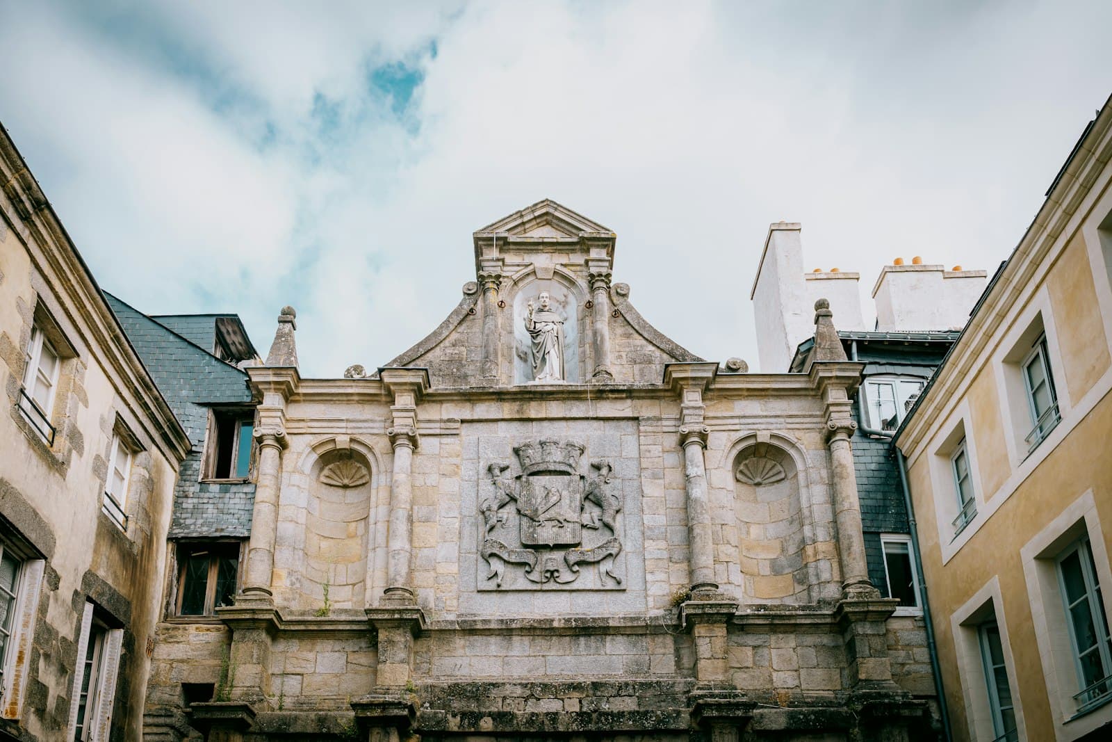 Saint-Pierre (Saint Pierre and Miquelon) — Ornate stone facade with coat of arms and cloudy sky