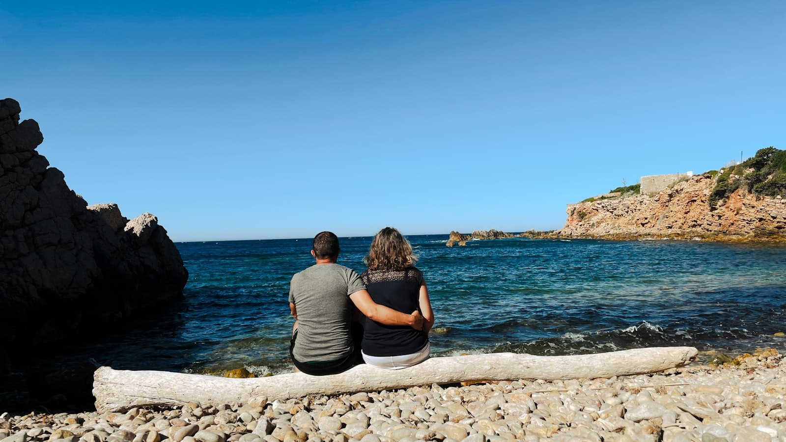 Sanary-sur-Mer — Couple sits by the sea, enjoying the view.