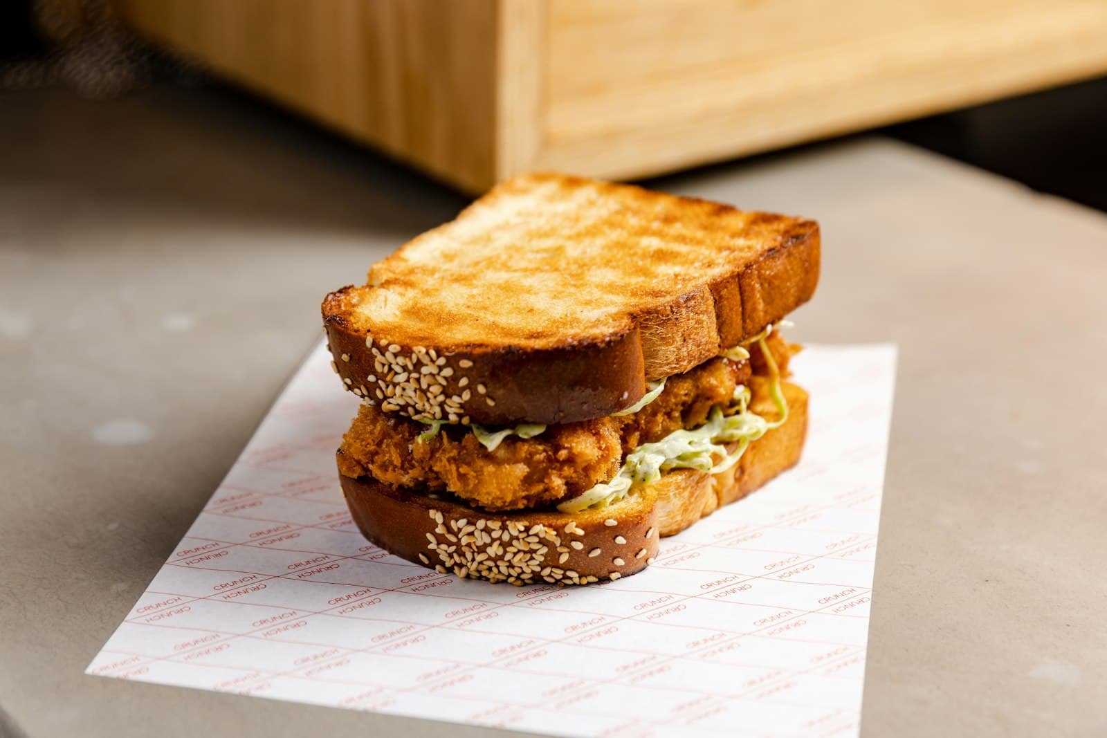 Sandwich — a chicken sandwich sitting on top of a piece of paper