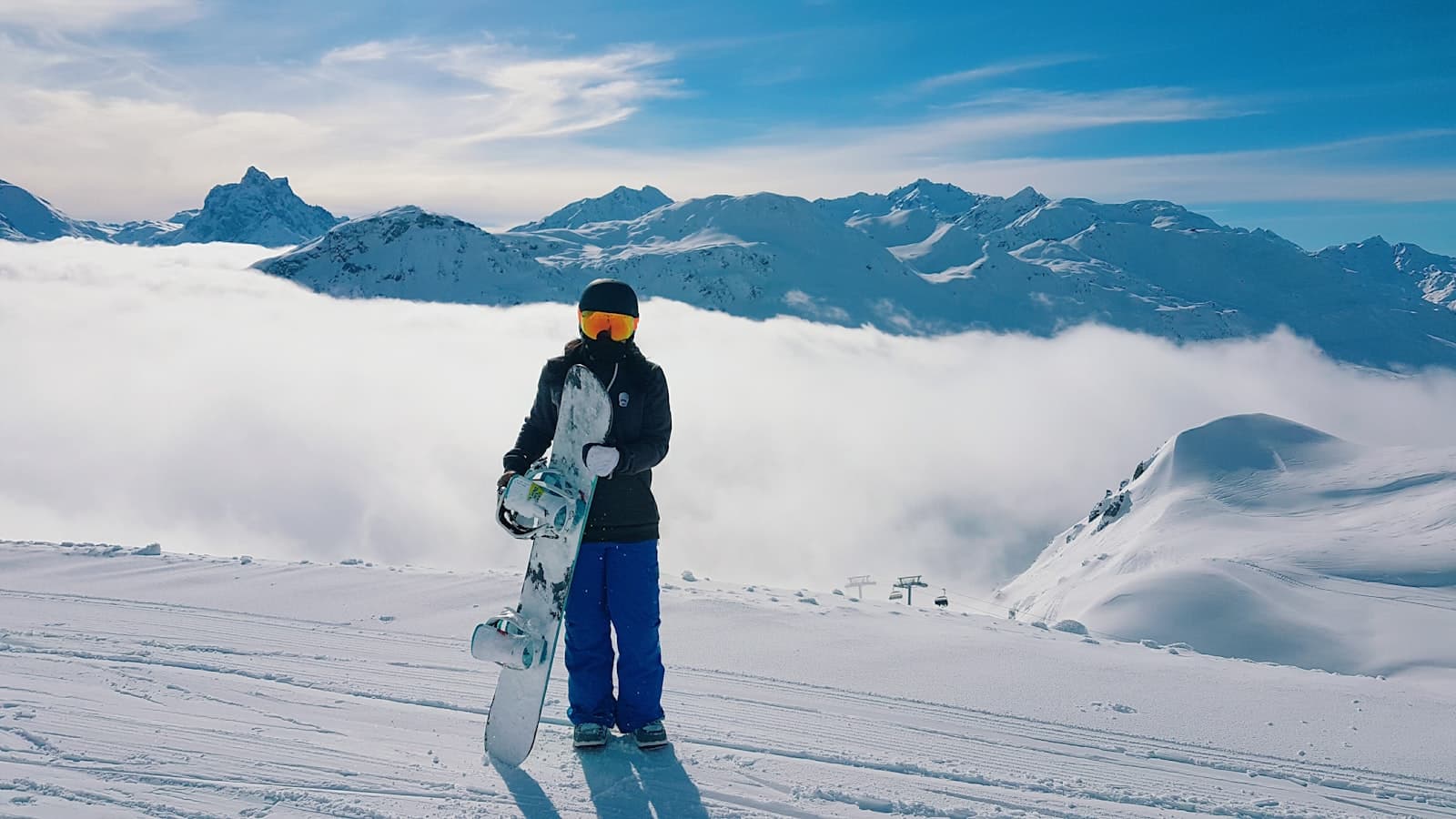 Sankt Anton am Arlberg — man carrying snowboard standing on snow-covered mountain