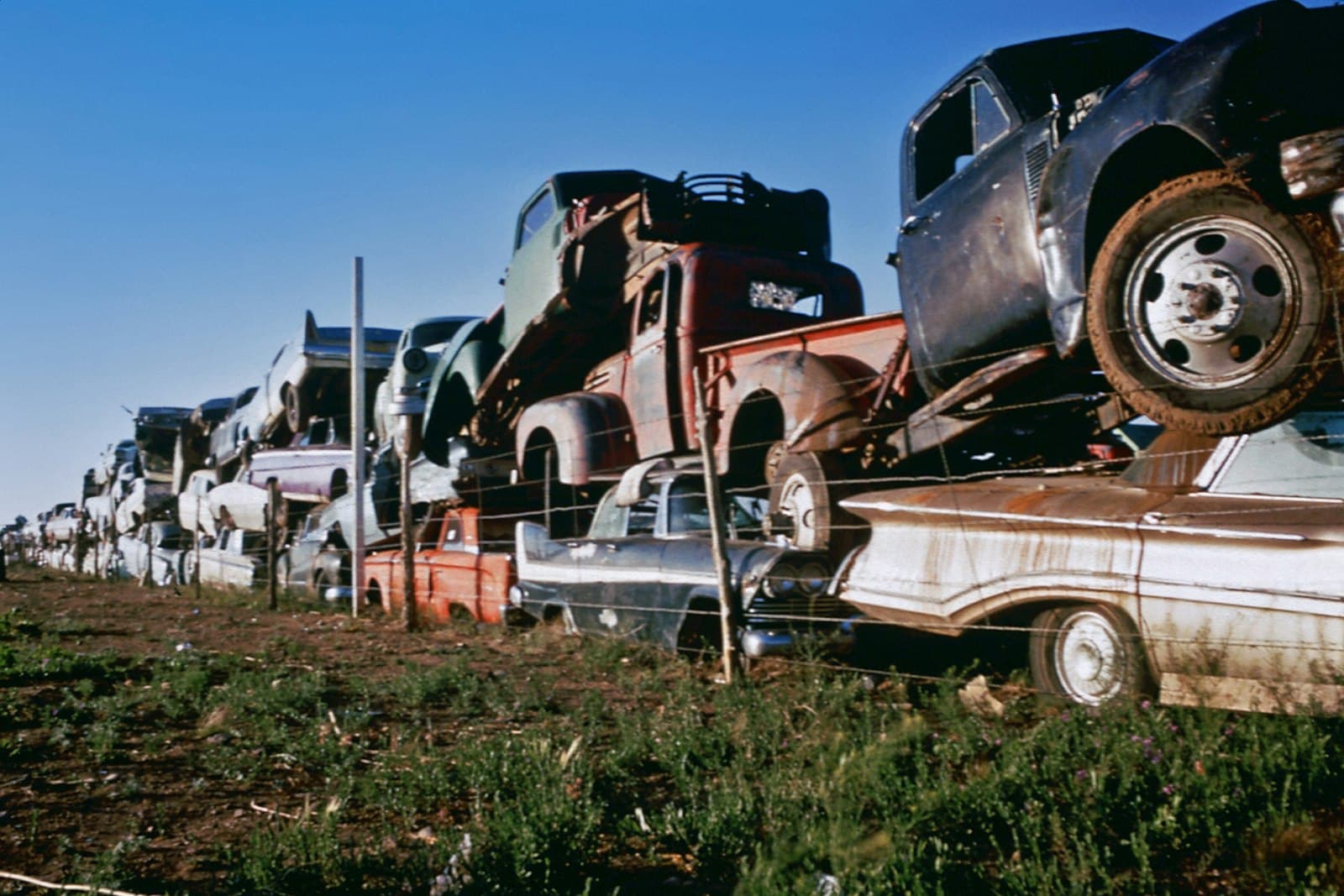 Santa Fe — a row of old trucks sitting on top of a grass covered field