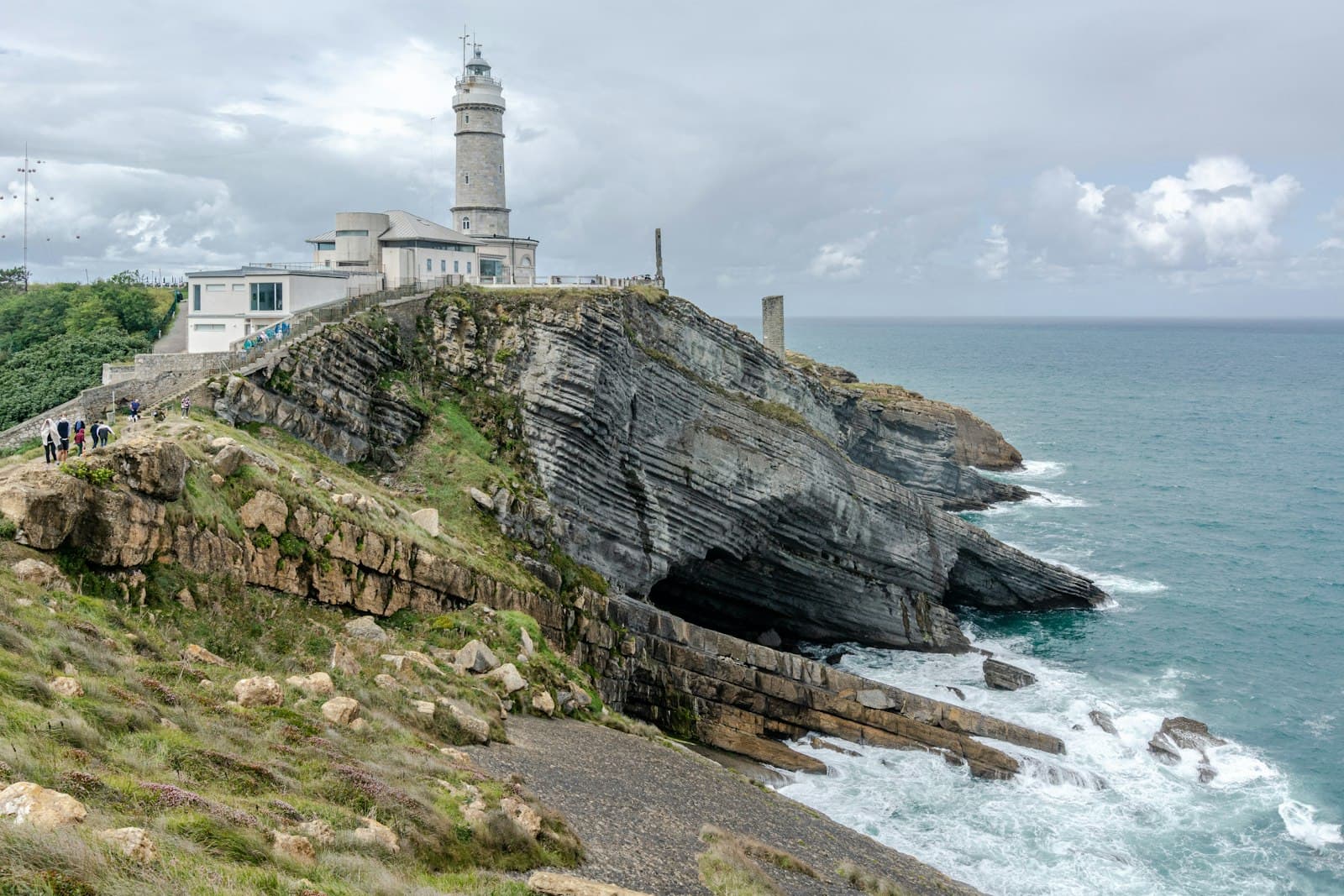 Santander — white lighthouse on cliff by the sea during daytime
