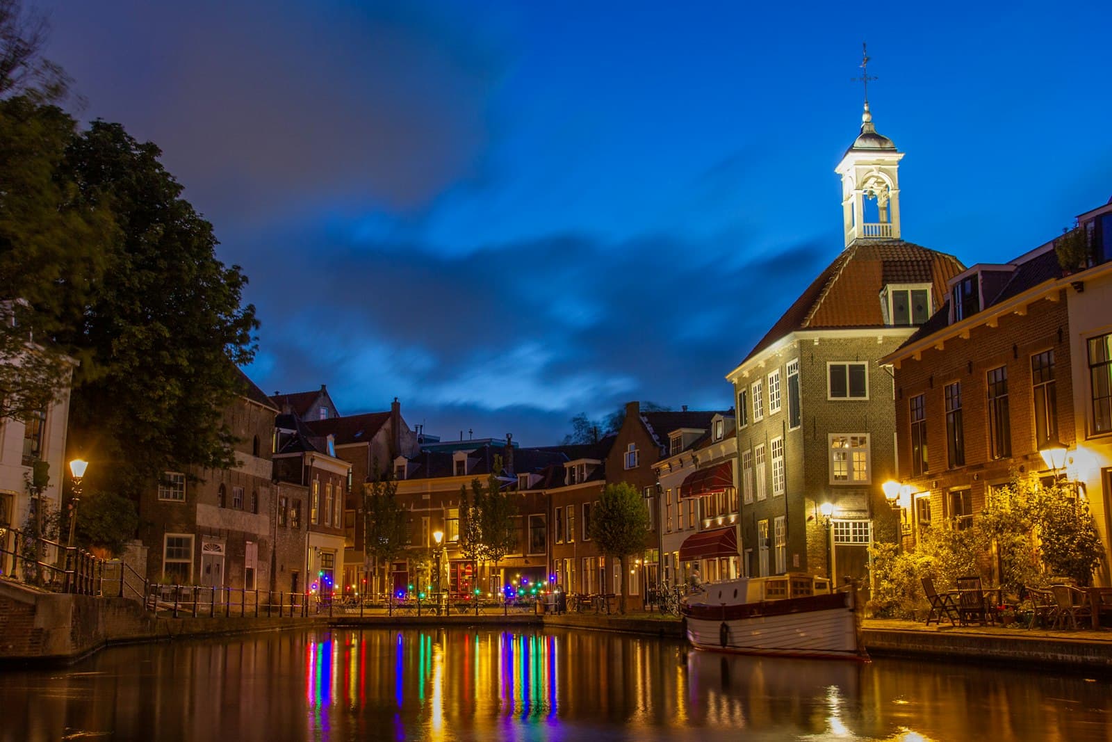 Schiedam — brown and white concrete building near body of water during night time