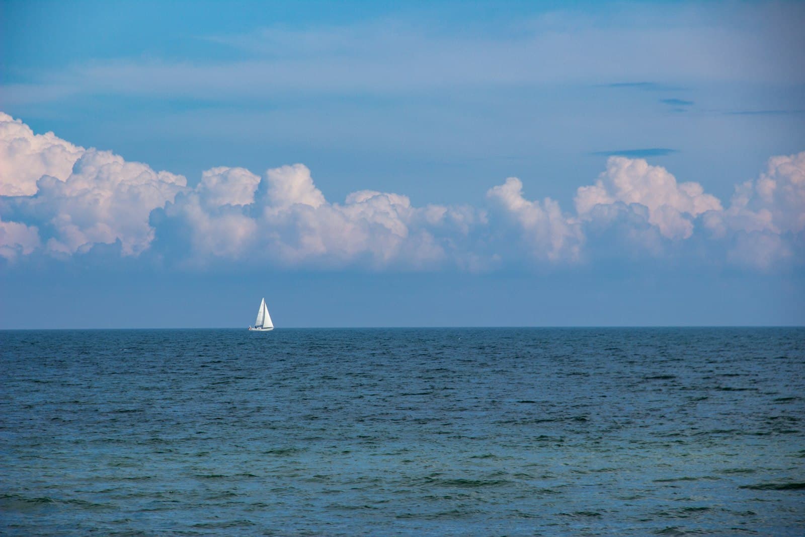 Schleswig — sailboat on sea under white clouds and blue sky during daytime