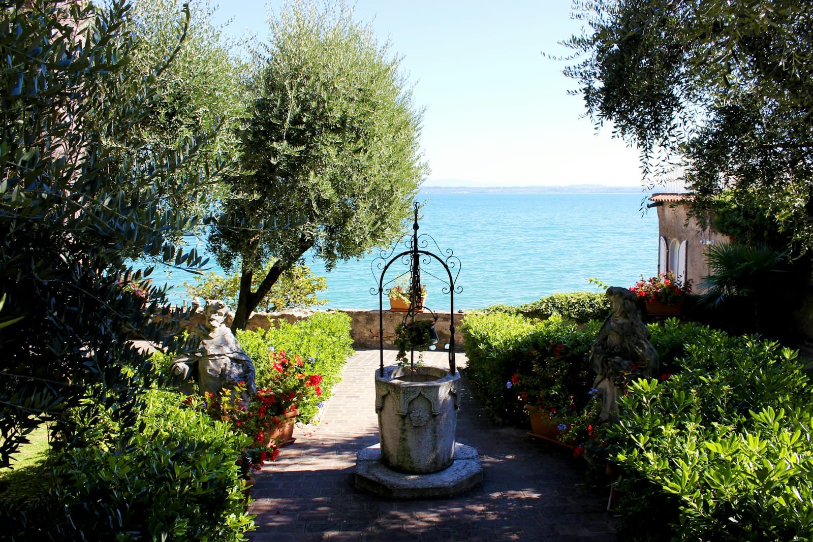 Sirmione — green trees on gray concrete floor near body of water during daytime