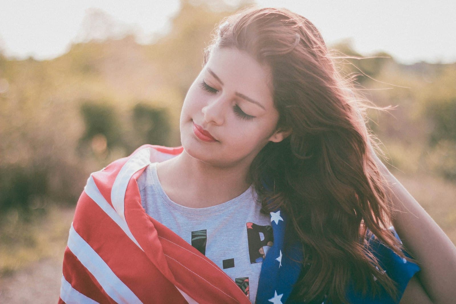 Sisters — close-up photo of woman holding hair while closing both eyes
