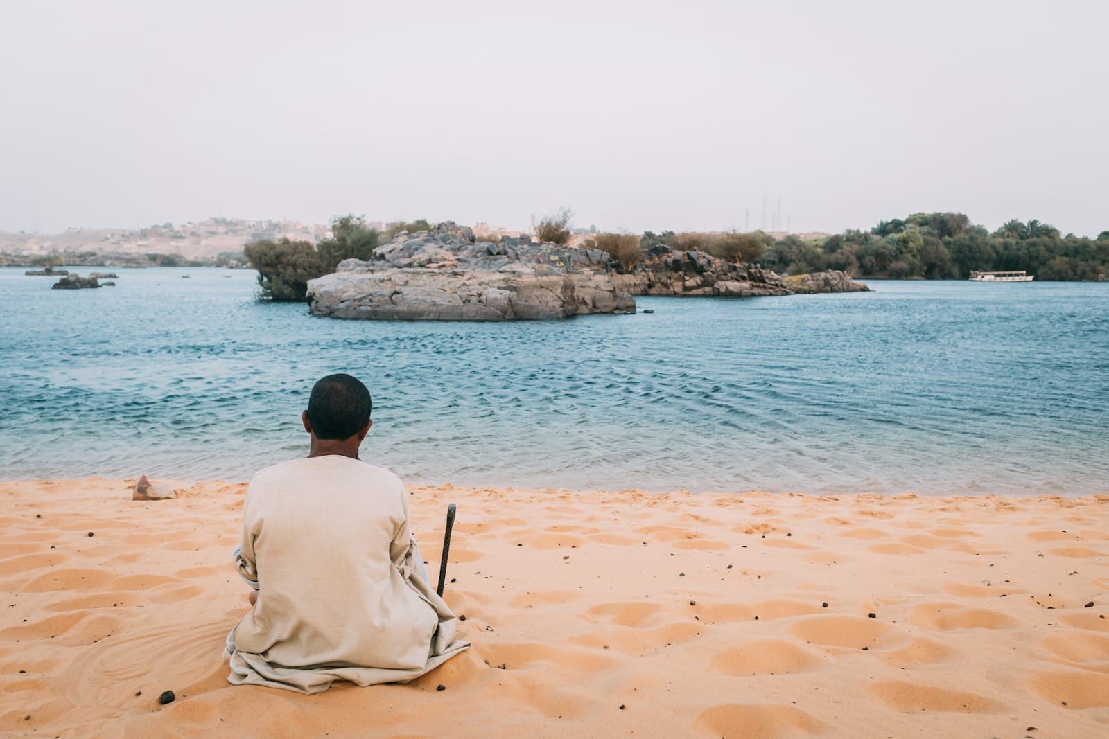 Siwa — man sits on sand dunes while watching the beach
