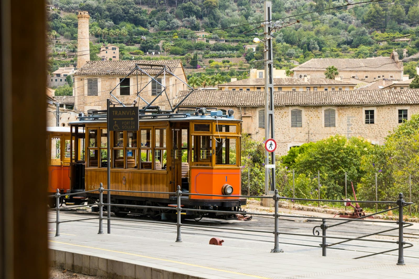 Sóller — An orange trolley car traveling down a street