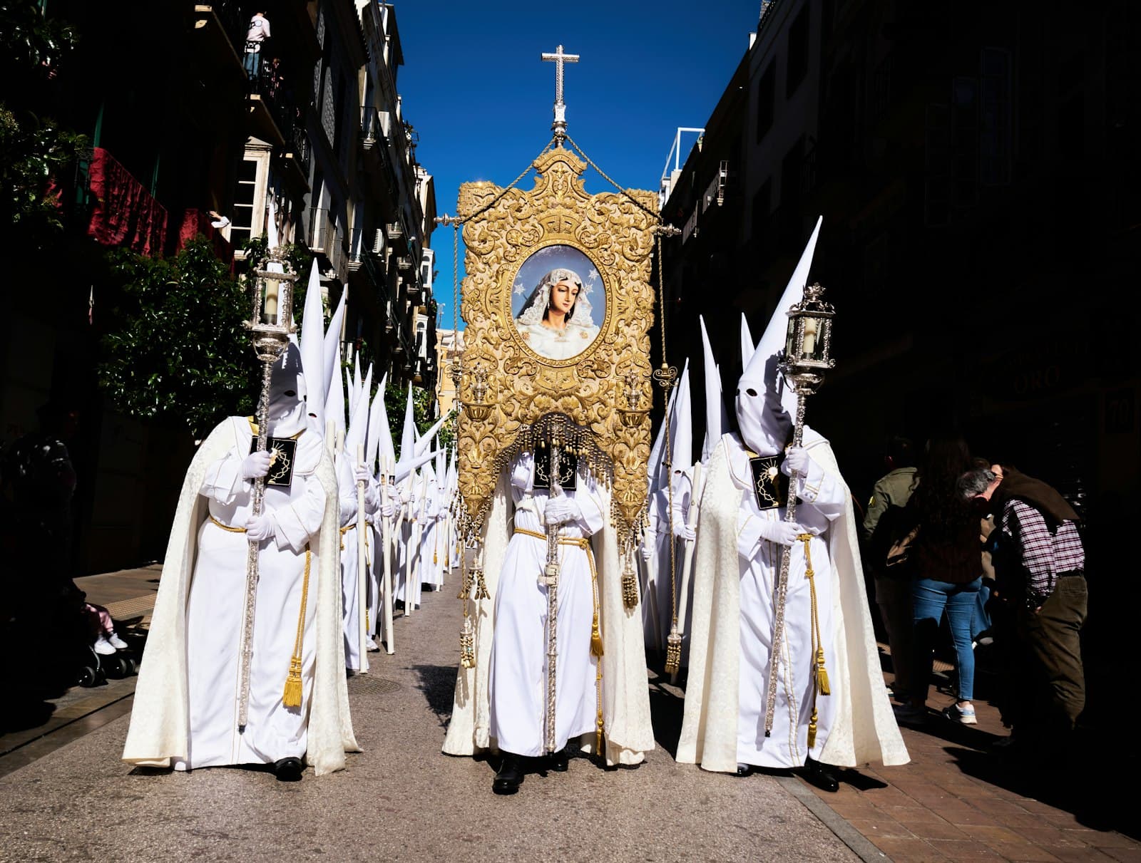 Sos del Rey Católico — Holy week procession with white-robed figures and a golden float.