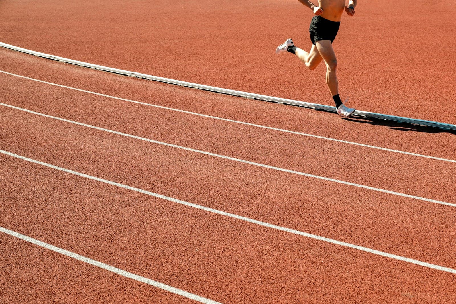 Sosnowiec — A person runs on a red athletic track