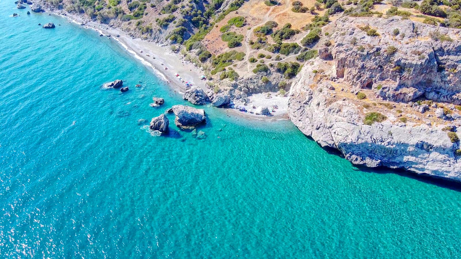 Sounion — green and brown mountain beside body of water during daytime