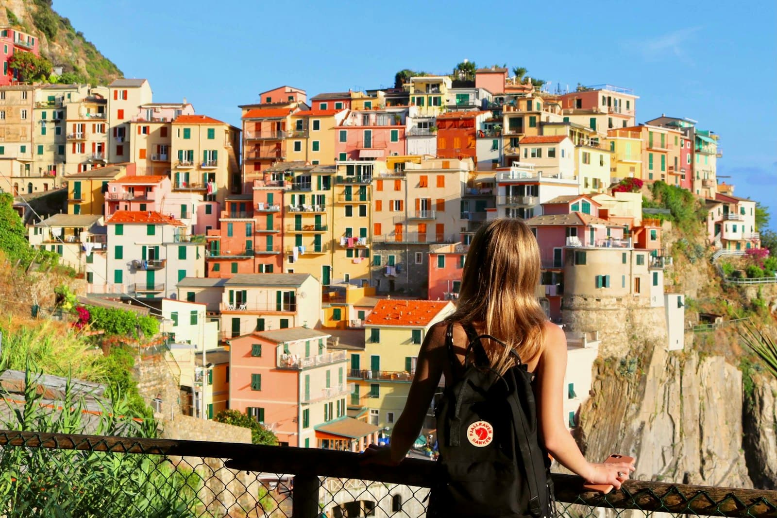 Sovana — woman in black leather jacket standing near black metal fence during daytime