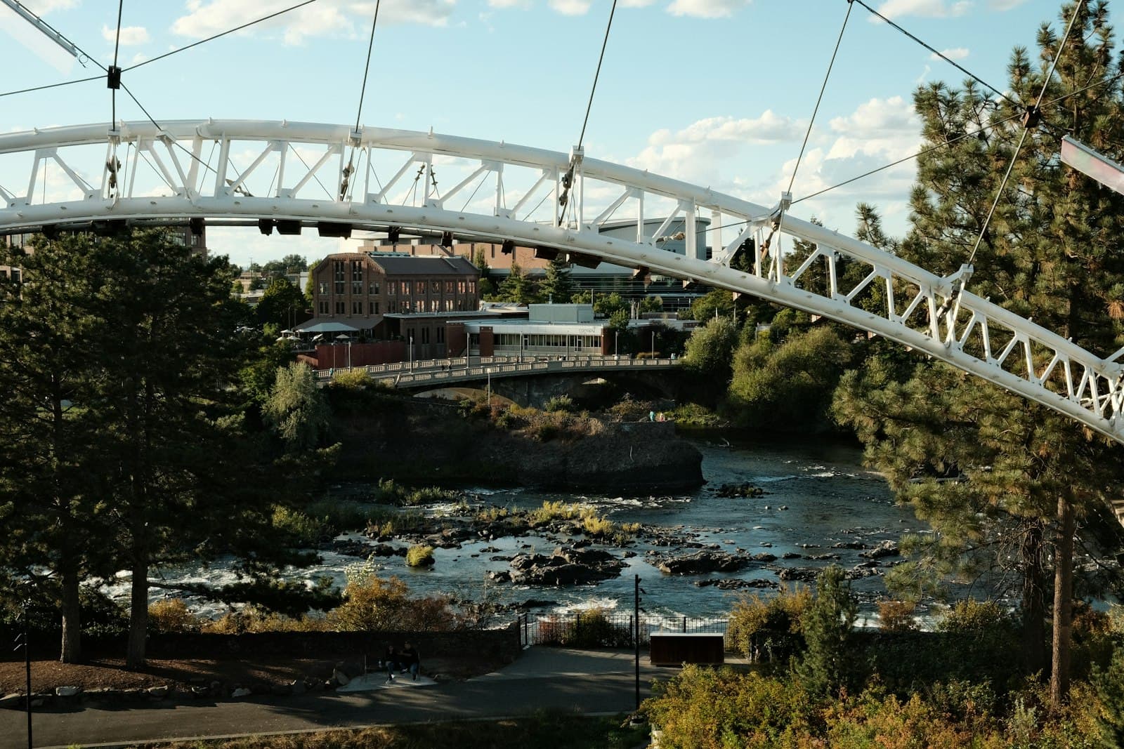 Spokane — A white bridge over a river with a bridge in the background