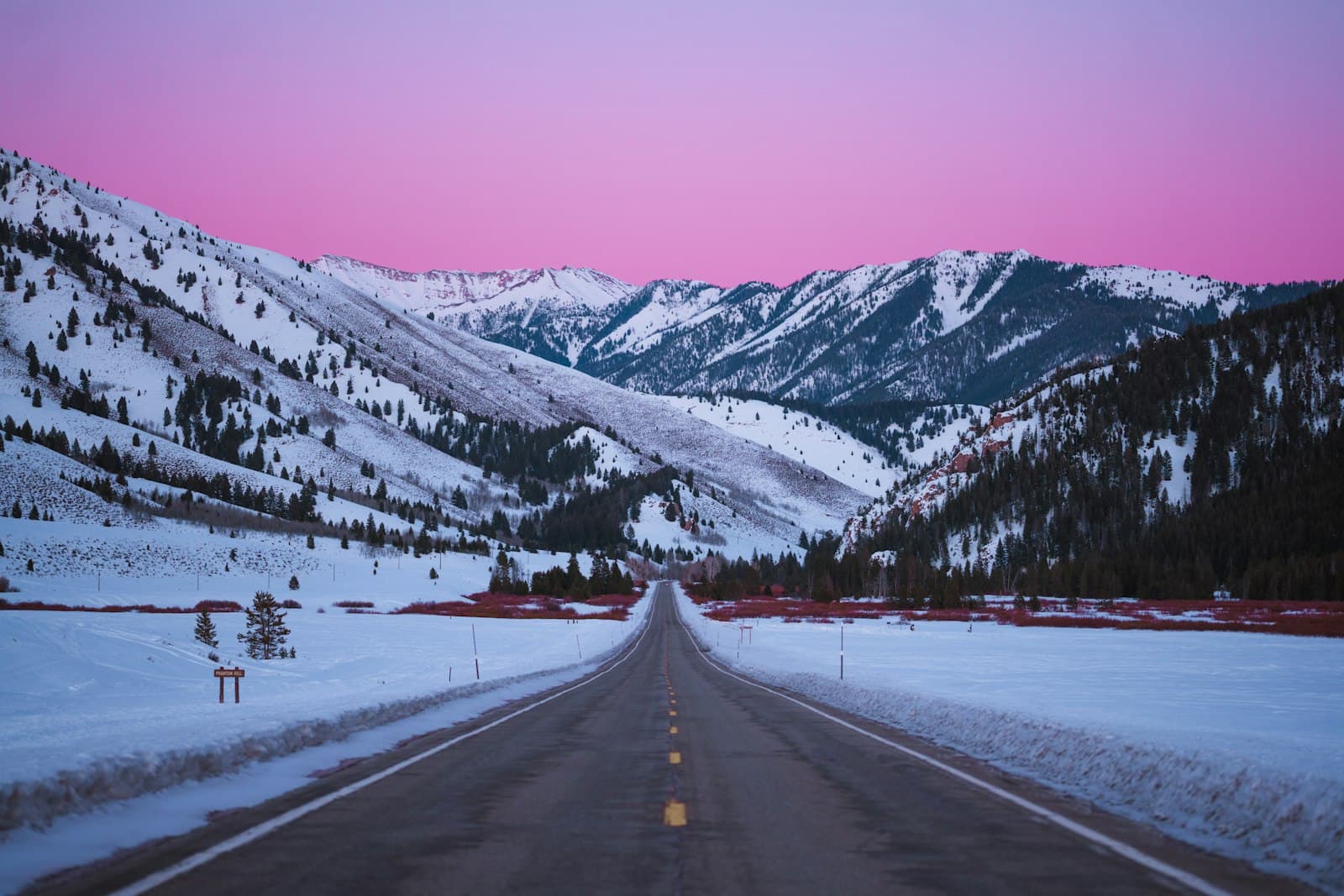 Stanley — Empty road through snow-covered mountains at dusk