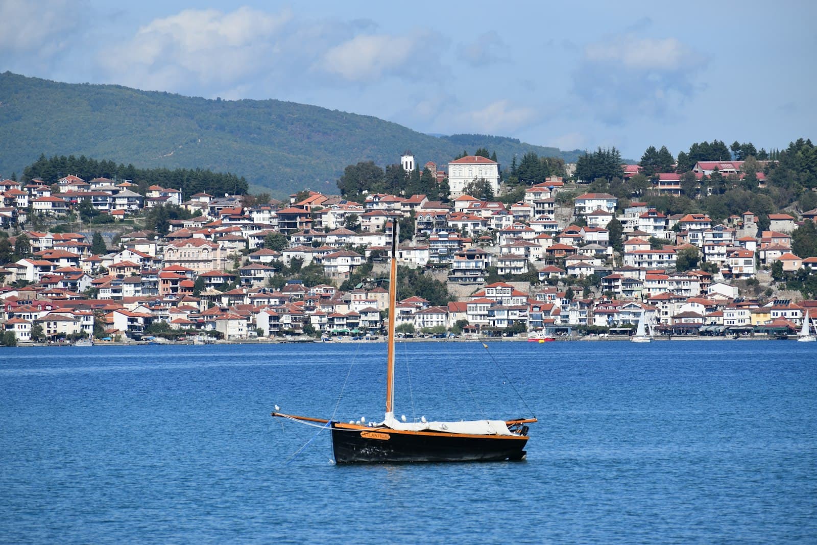 Strumica — brown boat on body of water near city buildings during daytime