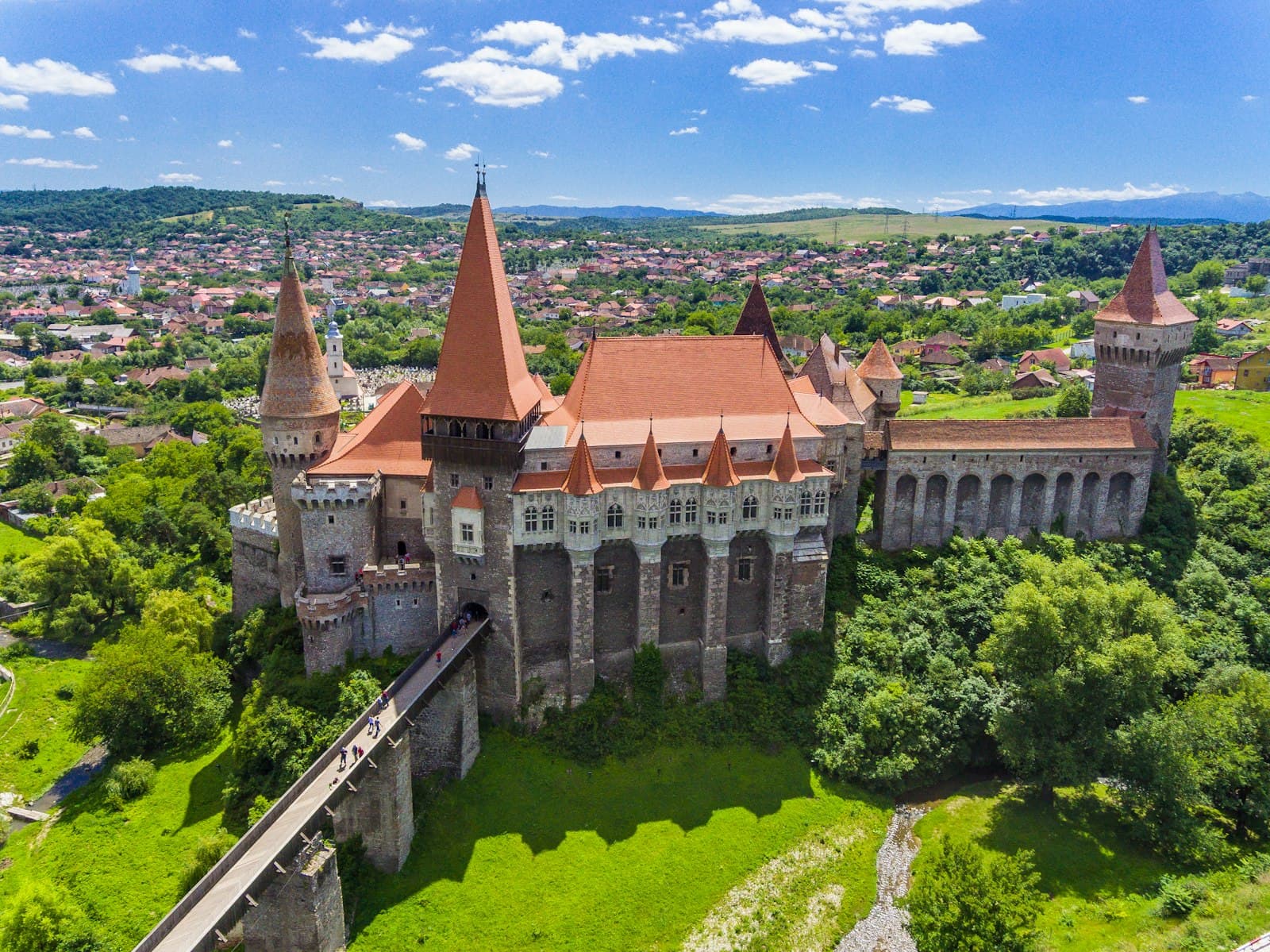 Suceava — grey and brown concrete castle near green trees under blue sky during daytime