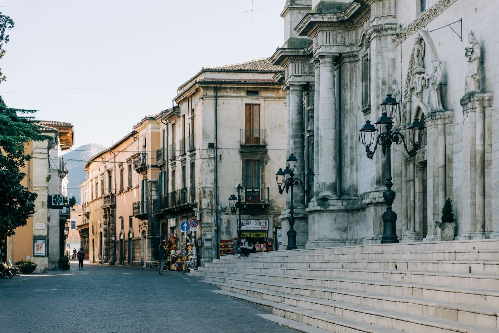 Sulmona — a city street lined with tall buildings and stone steps
