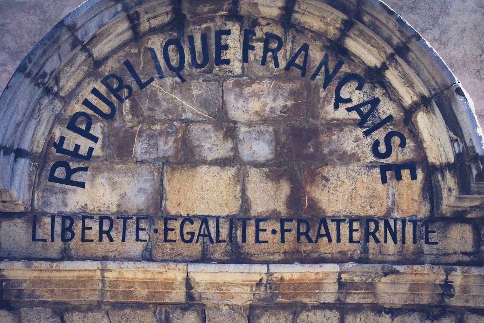 The Left Bank of the Writers — brown brick wall with black and white graffiti