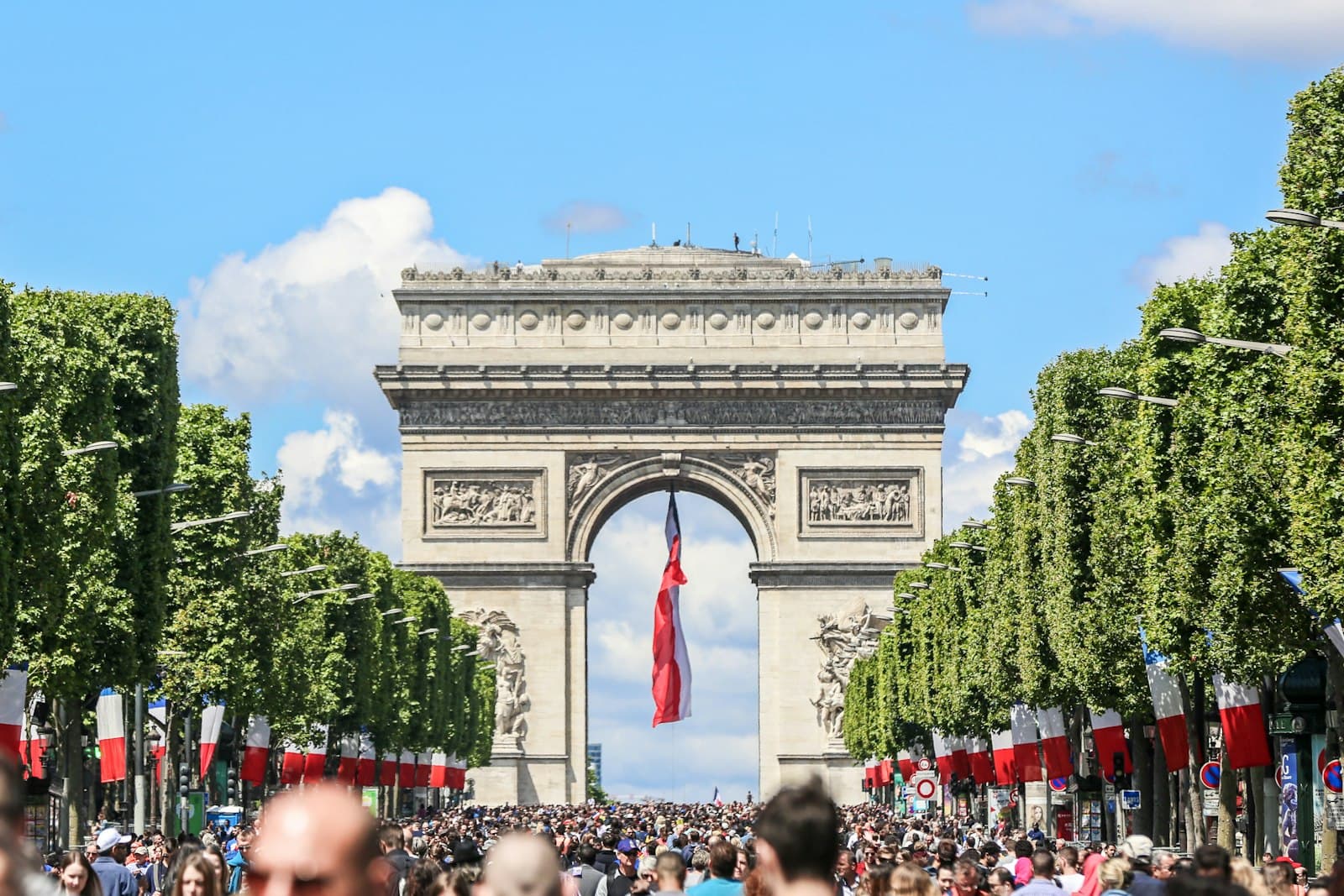 Thouars — a large group of people in front of a large stone arch with Arc de Triomphe in the background