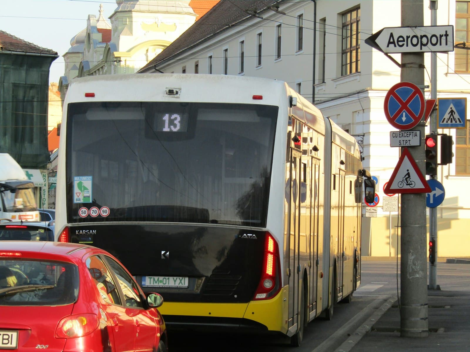 Timișoara — A city street filled with traffic next to tall buildings