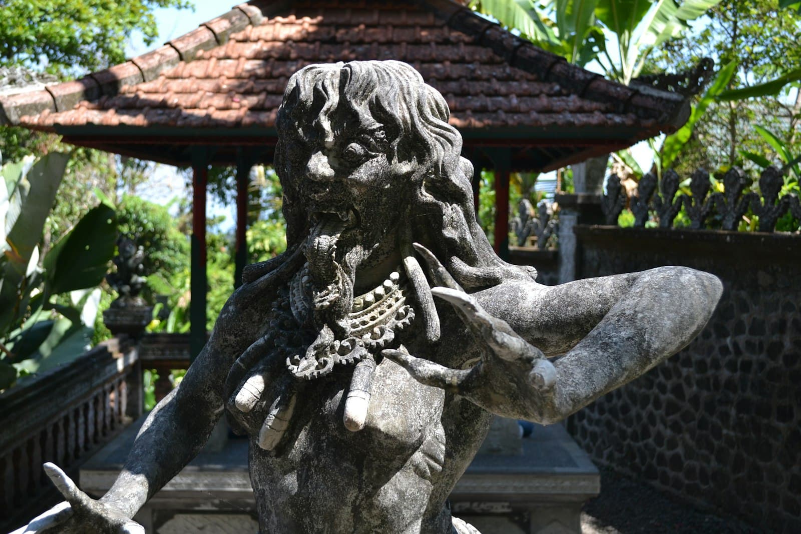Tirta Gangga — a statue of a man with a chain around his neck