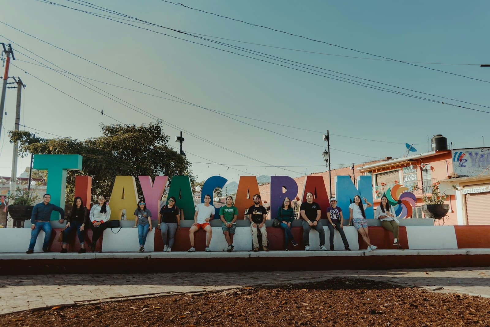 Tlayacapan — a group of people sitting in front of a large sign