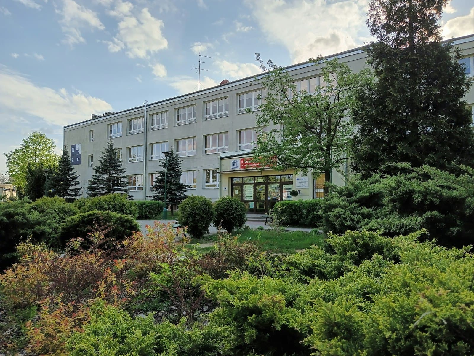 Tomaszów Mazowiecki — a building with a lot of trees and bushes in front of it