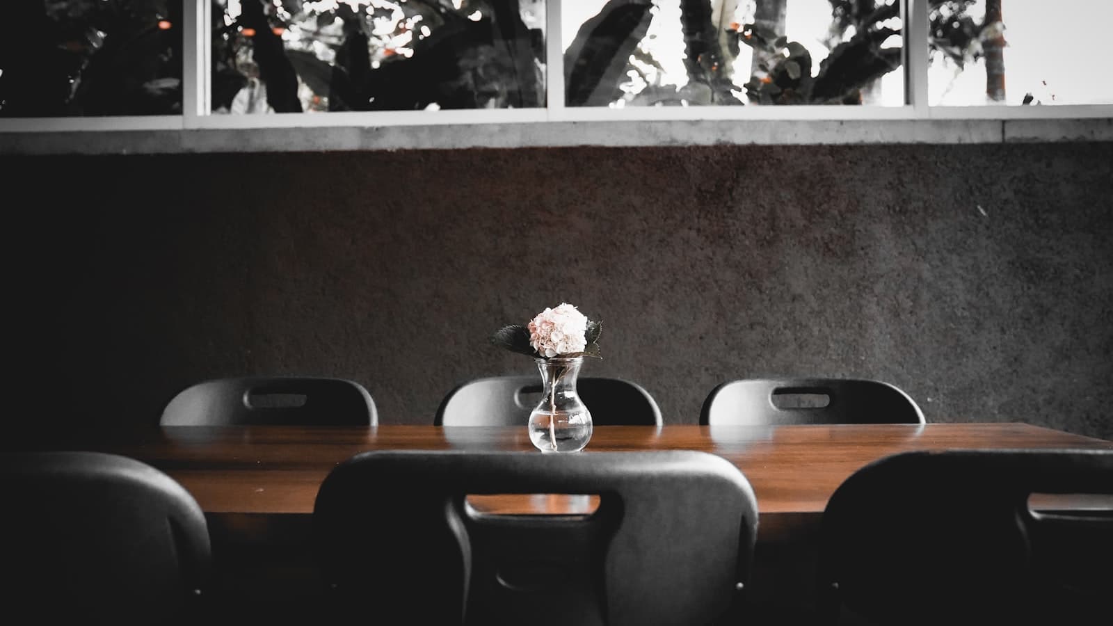 Tomohon — Dining table with a flower, surrounded by chairs.