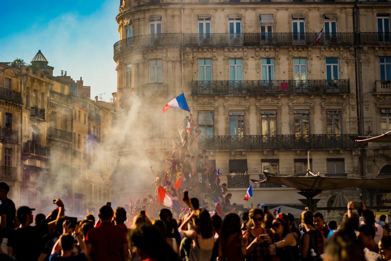 Tulle — people waving flag of France near building