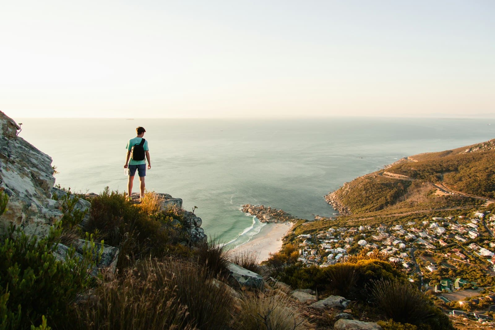 Underberg — person standing on the edge of cliff overlooking body of water
